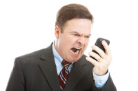 Angry businessman yelling into a cellphone.  Isolated on white.